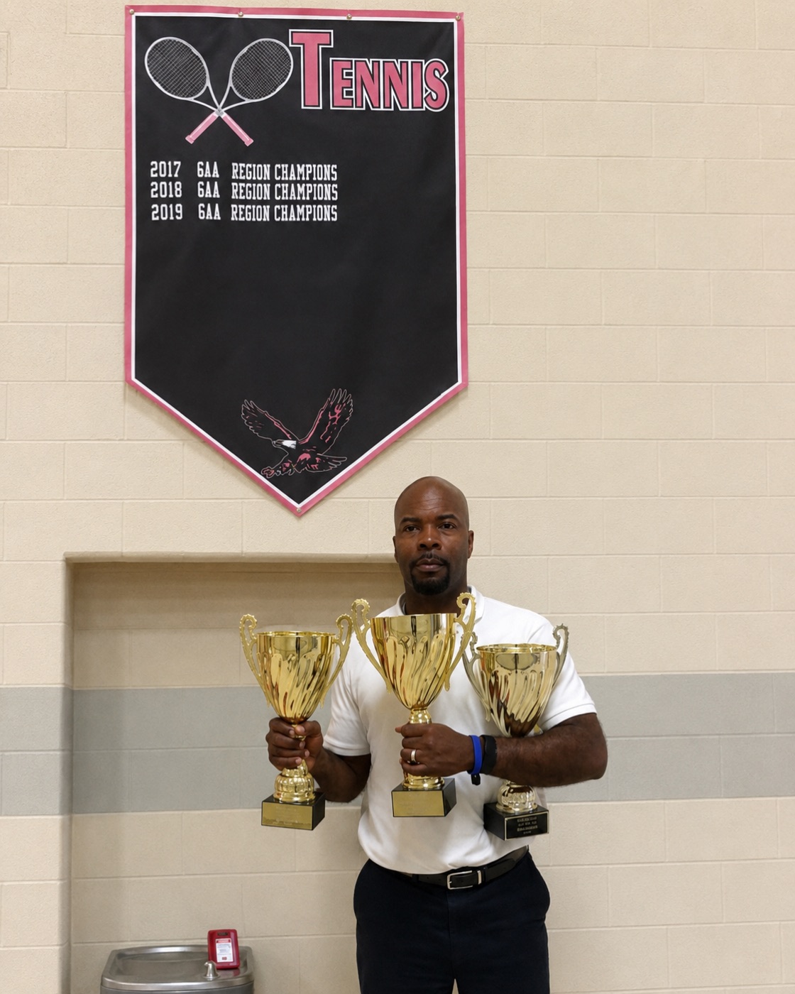 Coach Amani Mitchell, founder of Team Blue Tennis, with championship trophies